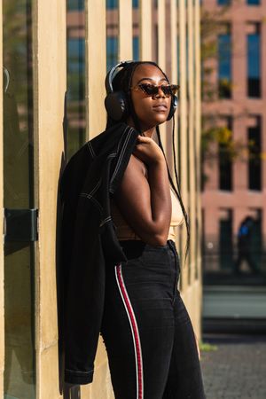 female listening to music outside modern building