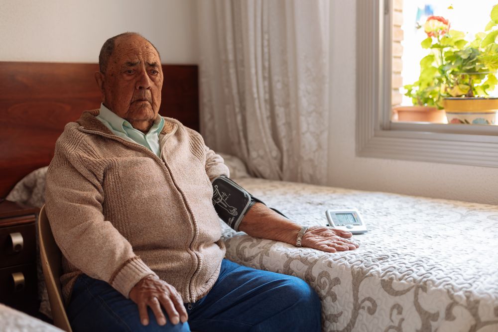 mature man checking his arterial pressure with machine