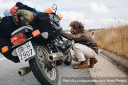 Man fixing motorcycle on side of road 0PPY20