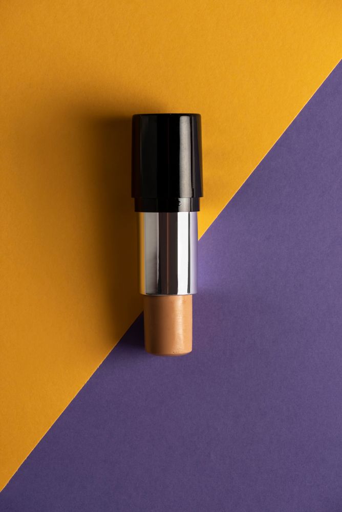 Concealer stick on modern background with geometric shapes.