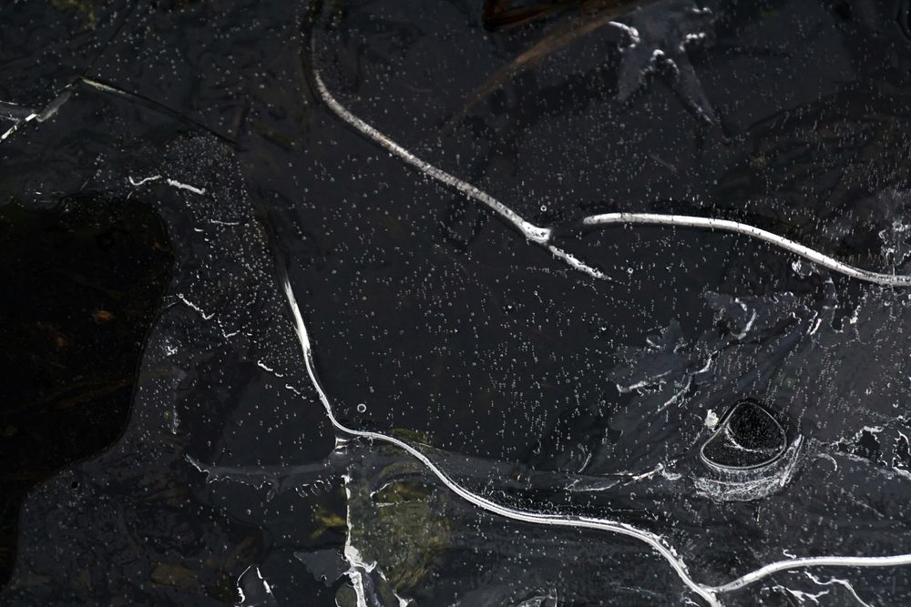 Fragment of thin ice on dark frozen river