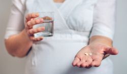 Unrecognizable pregnant showing pills