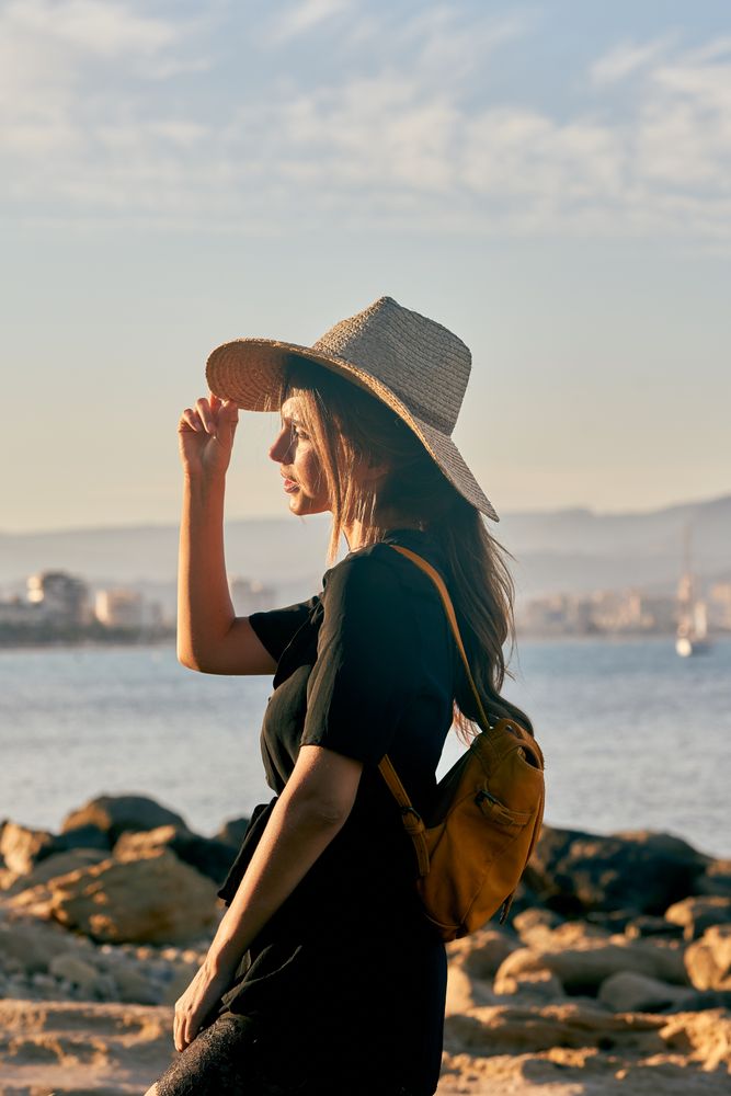Woman traveler in straw hat walking