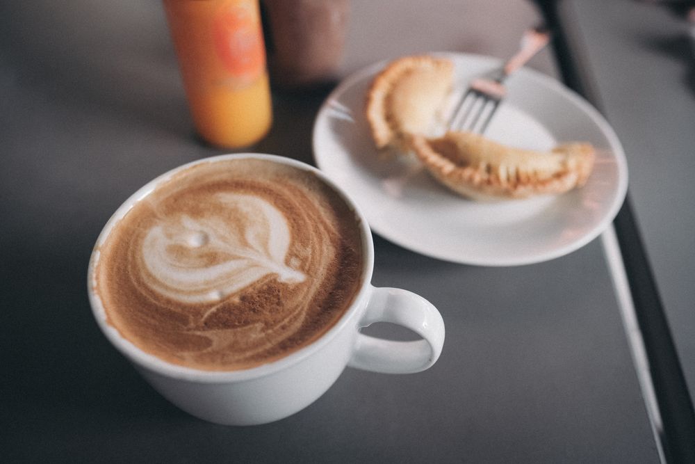 Close up of cappuccino and pastry on cafe table