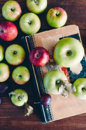 Apples and plum on book