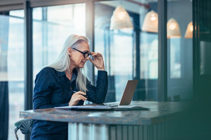 Older business woman working on laptop in office