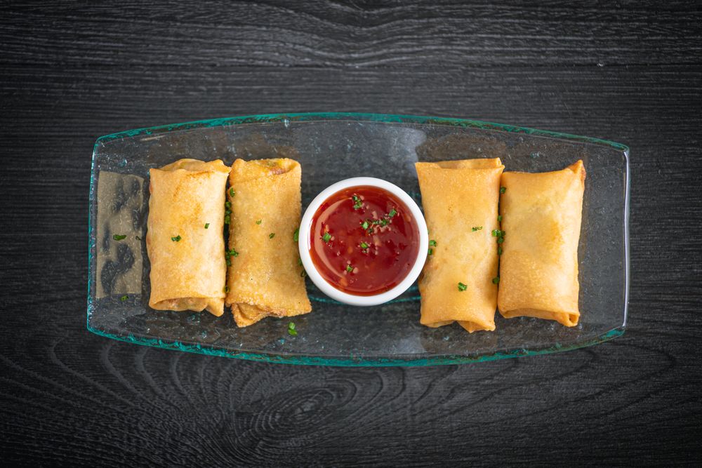 Vietnamese rolls with sweet chili on glass plate