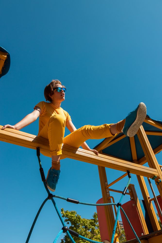 Cool stylish young woman in vibrant clothes on playground