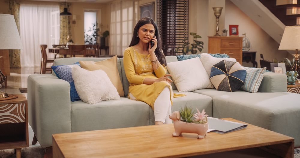 Indian Woman Engaged in a Lively Phone Call at Home: Worried Young Businesswoman Discussing Work Matters with Colleagues or Clients.