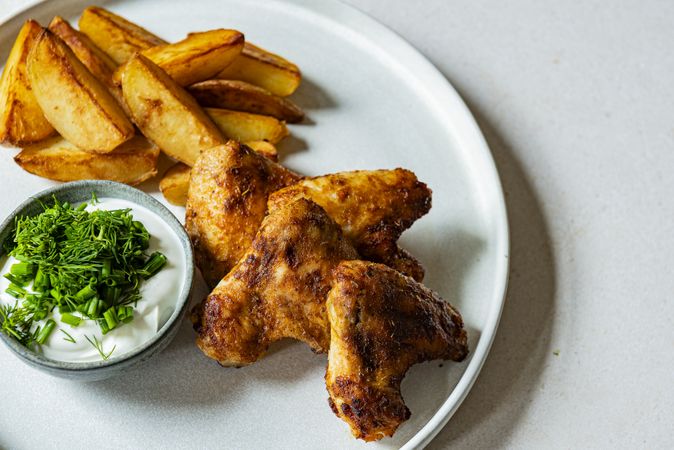 chicken wings with dip and potato wedges top view