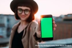 Smiling woman with glasses and hat with smart phone outside 5RDoDb
