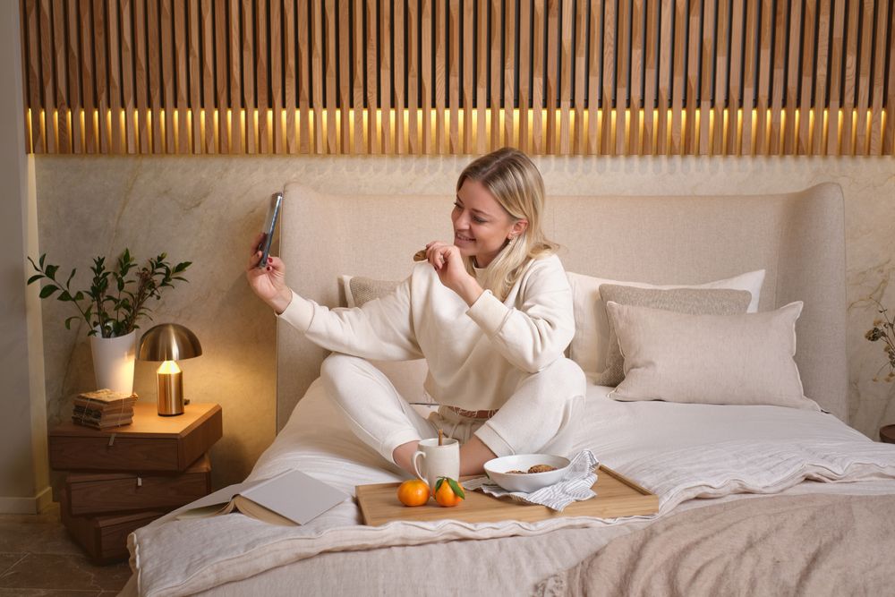Woman taking selfie with cookie in bed