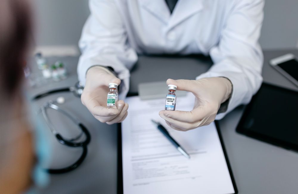 Doctor showing her patient two different coronavirus vaccine options