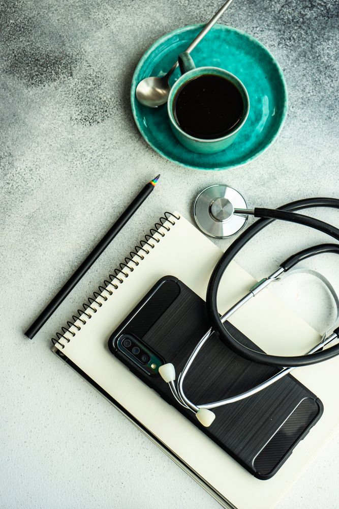 Top view of coffee cup with phone and notepad