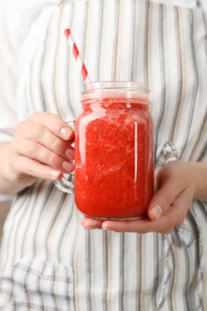Woman hold glass jar of strawberry cocktail, close up. Summer drink