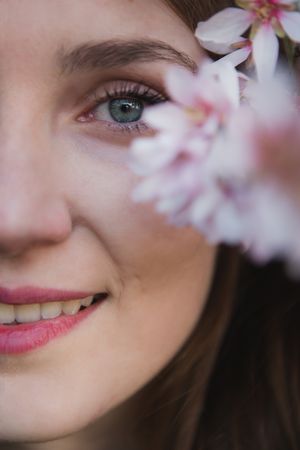 Young woman near tree twig with flowers