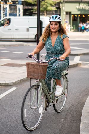 Happy Black woman riding in bike lane on city streets