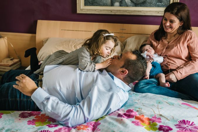 Happy family having fun in bedroom