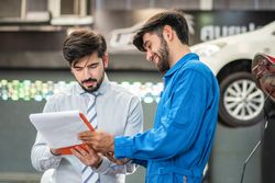 Client and mechanic talking about vehicle in auto repair shop