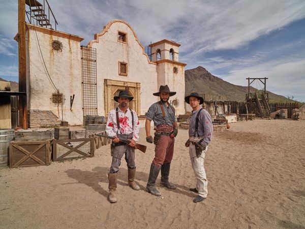 Three cowboys in front of Western movie set in Arizona