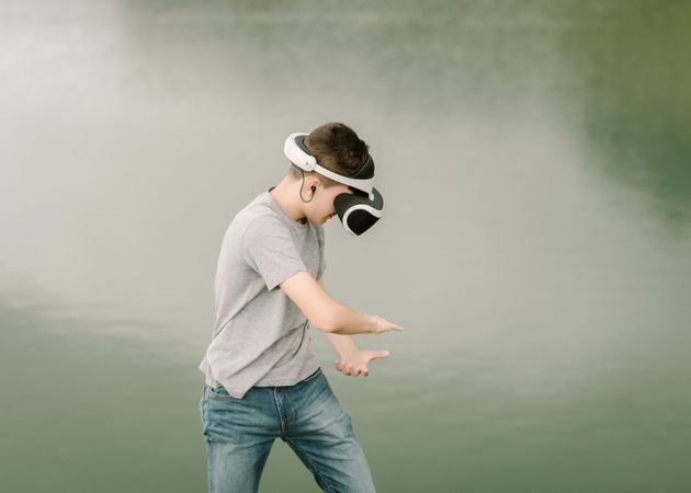 Young teenager with virtual reality glasses outdoors