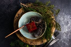 Top view of Christmas table setting with decorative fir and pine cones
