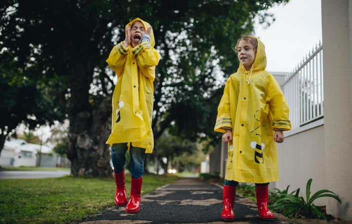 Two little children outdoors on rainy day