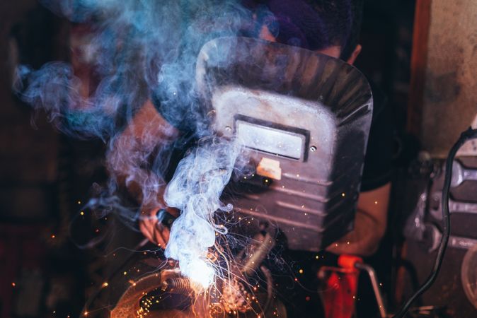 Professional welder in mask welding metal