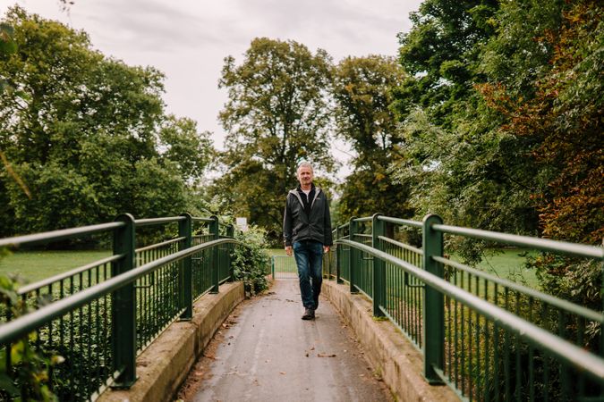 Man walking on bridge in public park