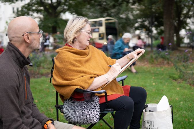 Woman sitting calmly outside at drawing class