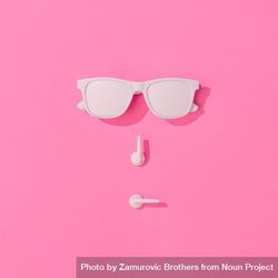Summer objects of sunglasses and EarPods making face on pink background 5kpmQ4