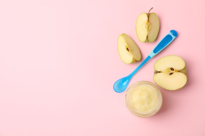 Vegetable puree, apples and spoon on pink background. Baby food