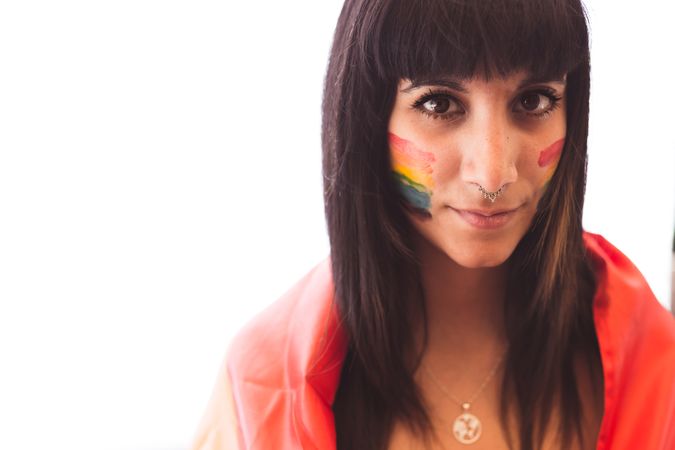 Brunette woman with LGBTIA symbol on face and straight hair