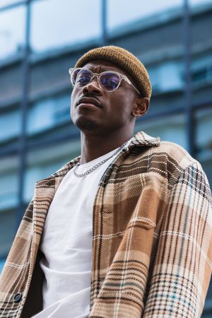 Stylish Black man resting on street