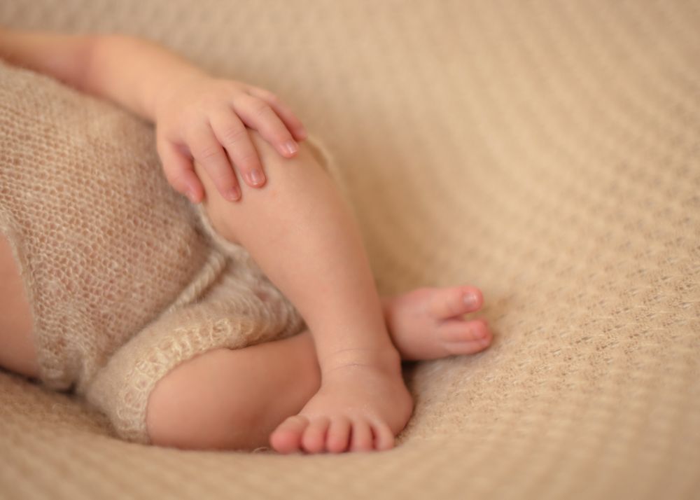 Crop baby lying crossed legs
