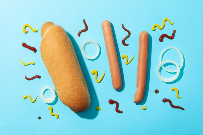 Ingredients for hot dog on blue background, top view