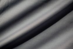 Wavy dark grey fabric background texture. shiny, glossy and elegant background.
