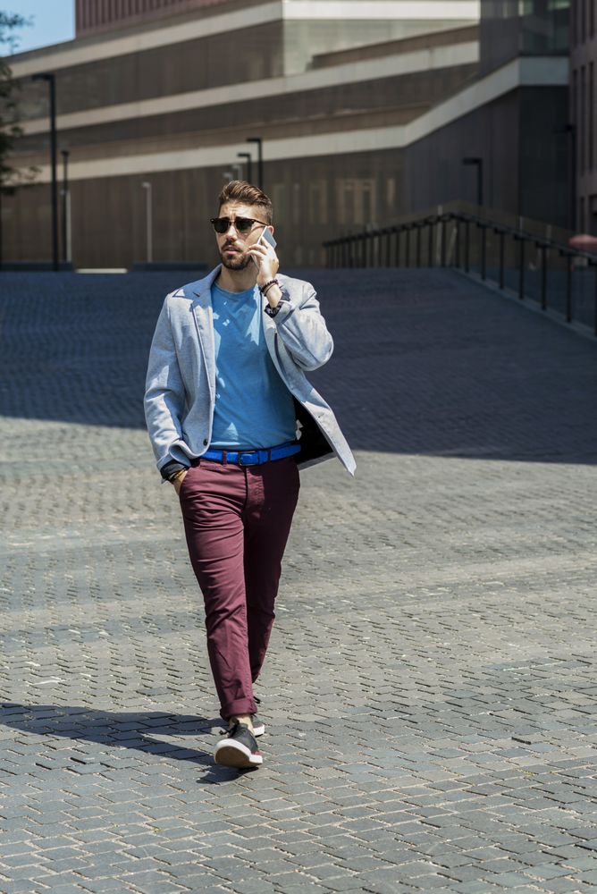 Young businessman talking on his phone while strolling outside