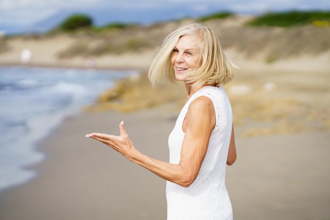 Happy mature woman with her arms making questioning gesture
