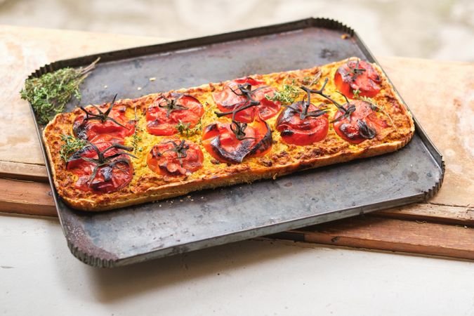 Yummy vegan pizza with tomatoes on baking sheet