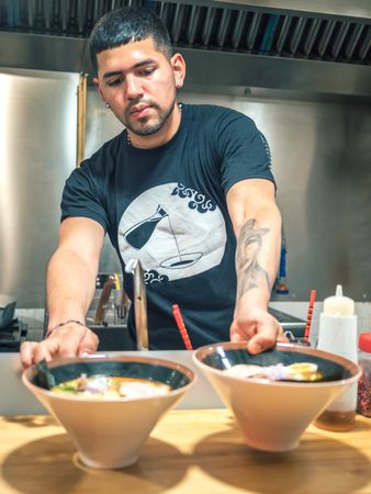 Male serving bowls with soup in restaurant