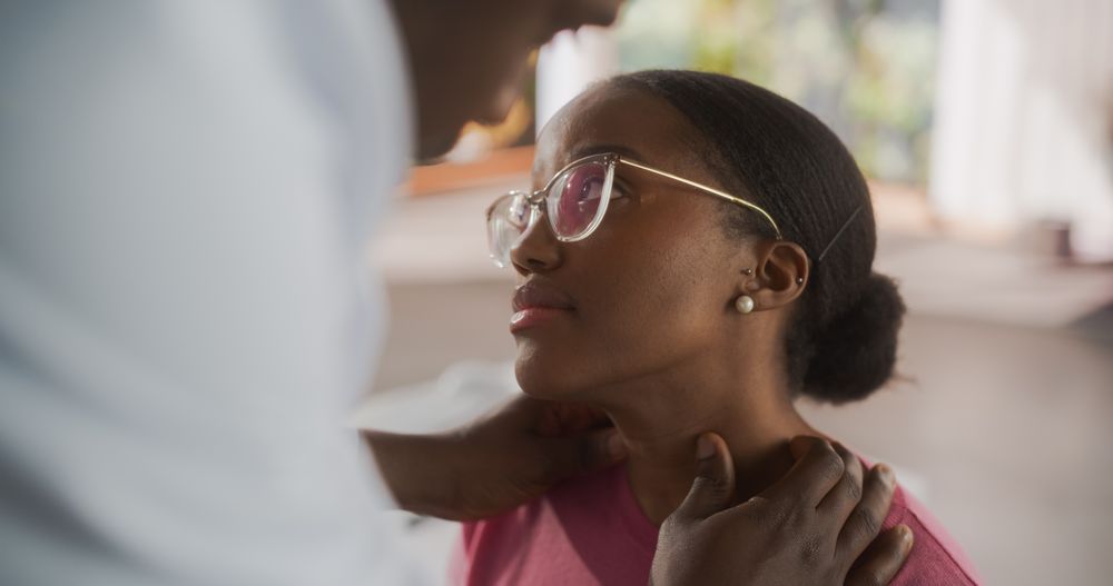 Black Physician Inspect Neck Muscles For Any Damages of a Female Patient