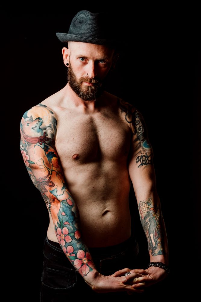 Young shirtless bearded guy with tattoos