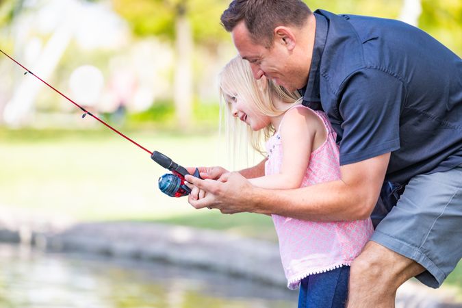 Young Father and Daughter Having Fun Fishing At The Lake