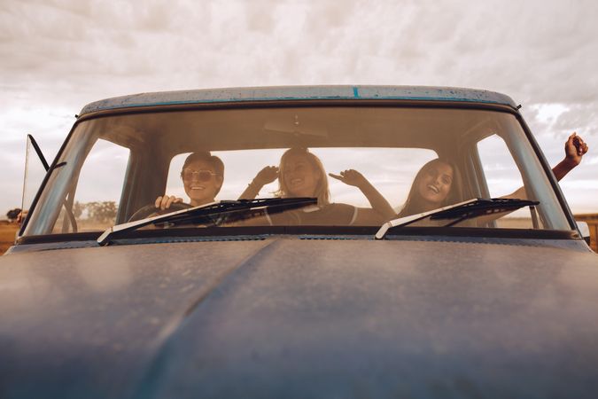 Three young women enjoying in car during vacation