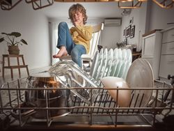 Boy sitting near modern dishwasher
