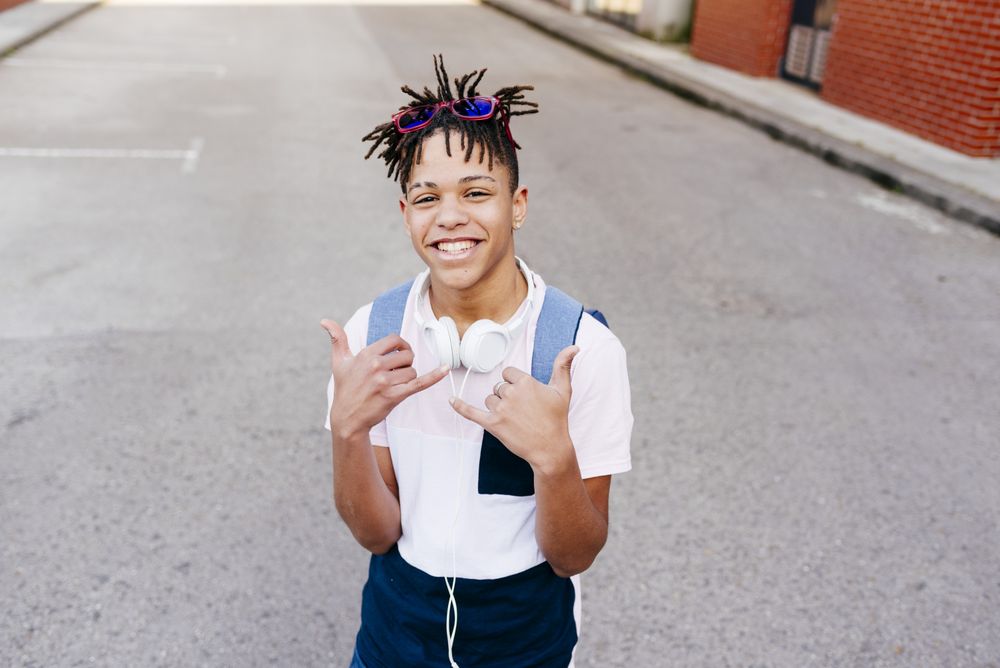 Young cheerful Black male standing on street