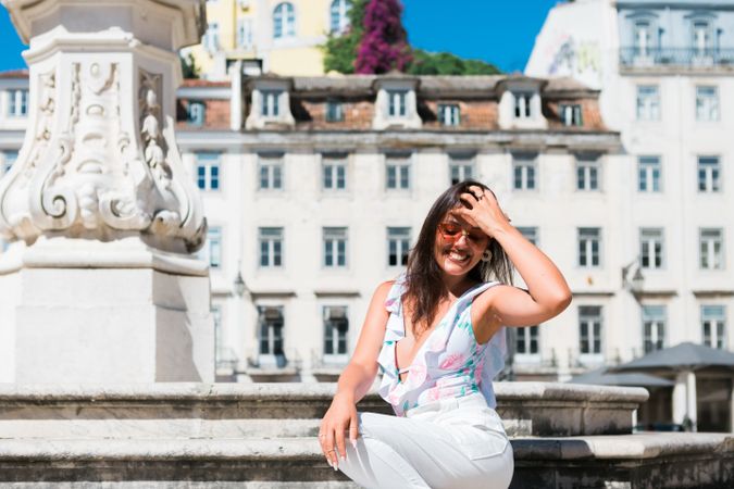 stylish woman in sunglasses sitting in street stairs