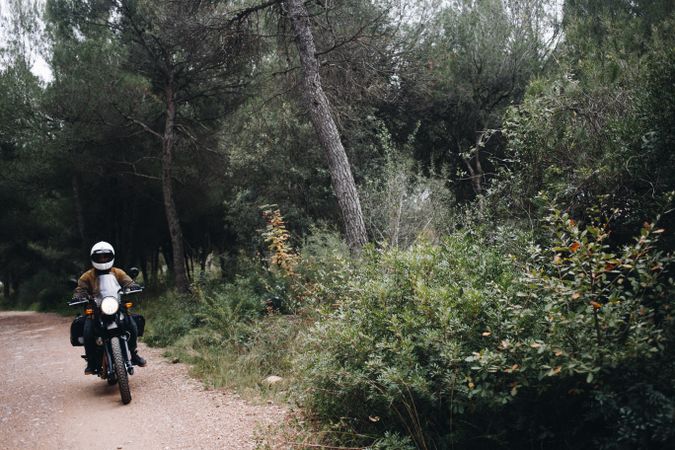 Person on motor bike in forest trail