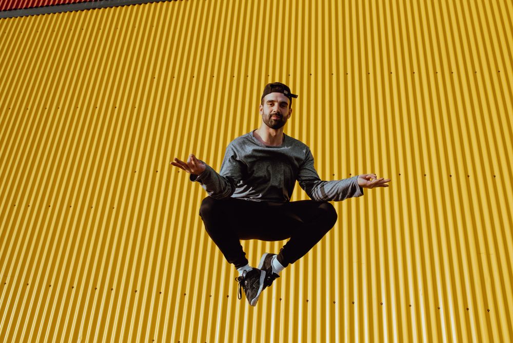 Man jumping near yellow wall